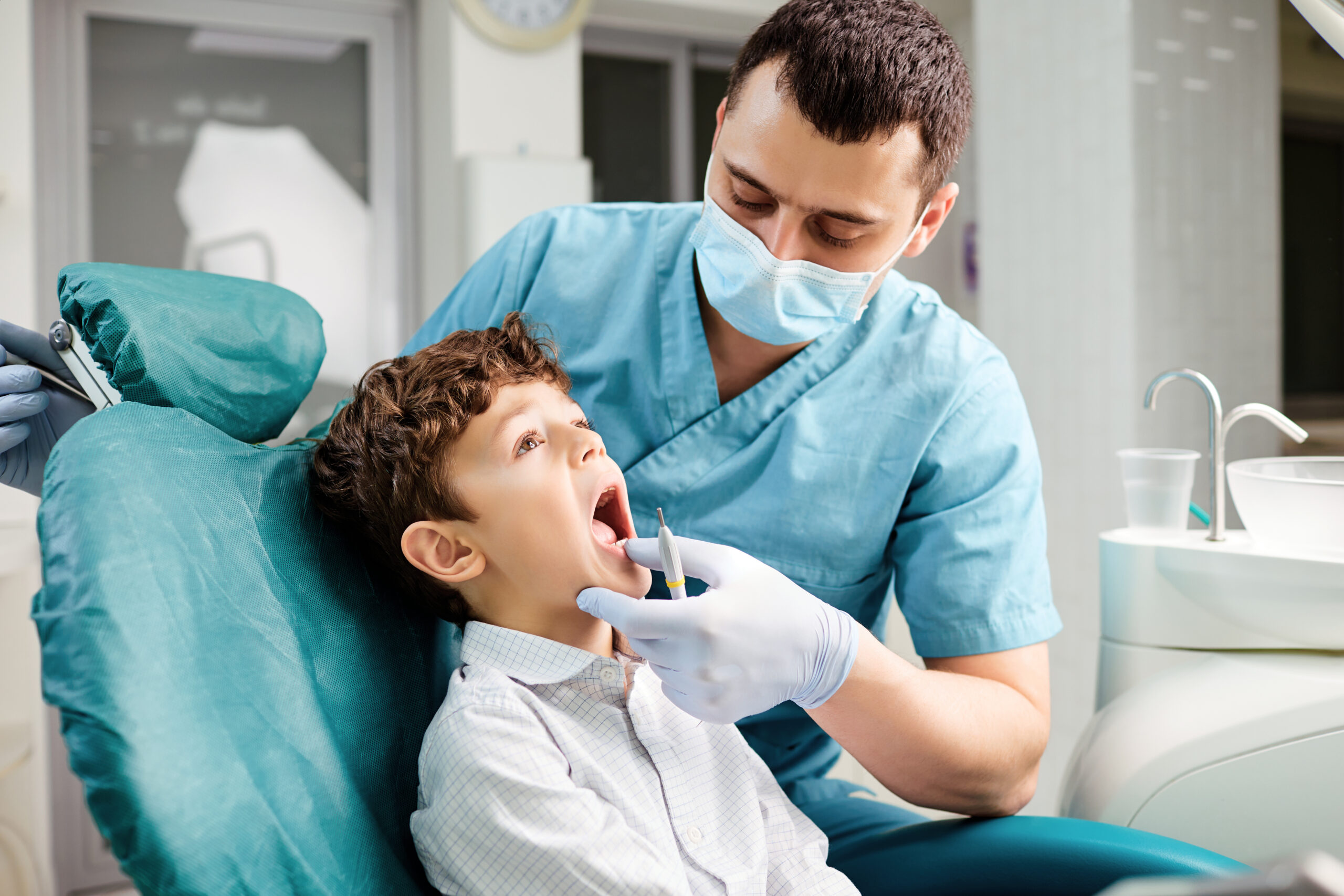 Dentist checks the child's teeth in the dental clinic.